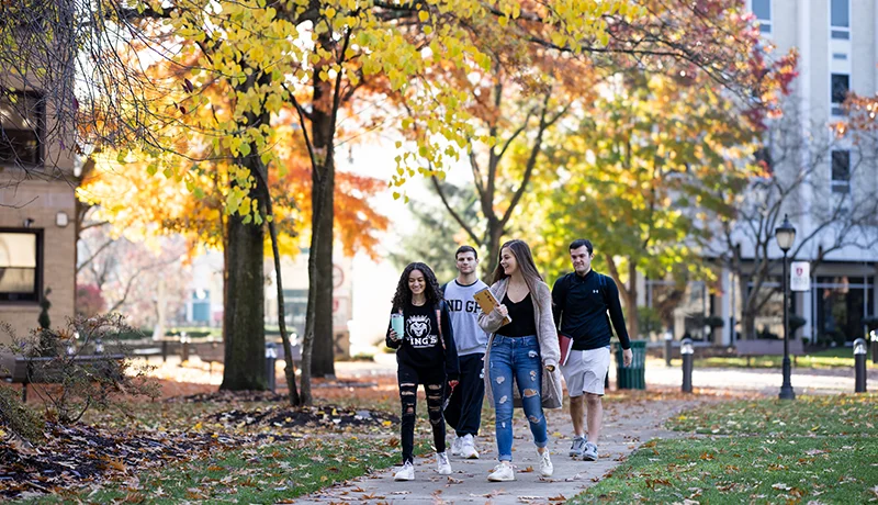 four students walking through campus