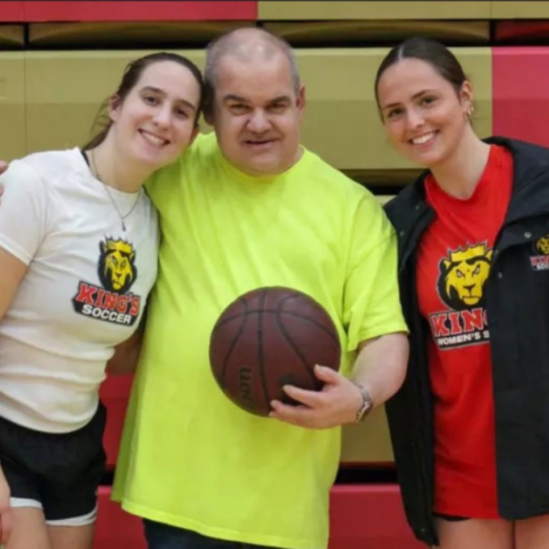 Participant smiling with basketball. 